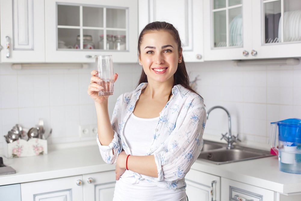 happy woman holding glass of water