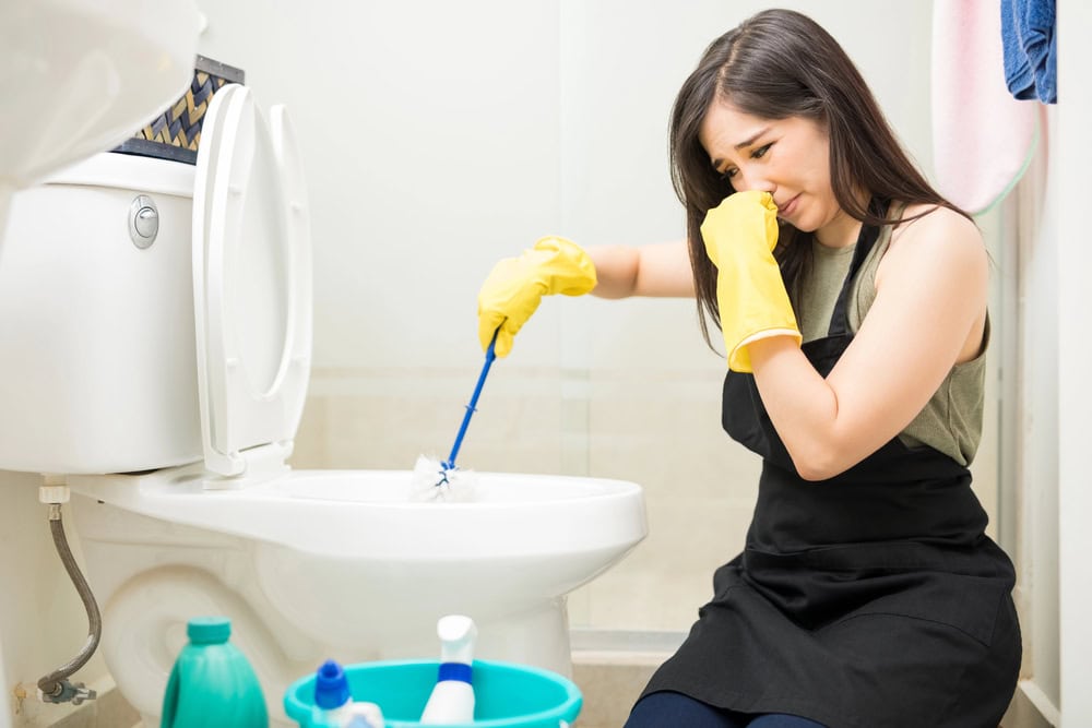 woman cleaning toilet bad smell